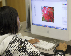 Student at a computer screen working on a photo of a leaf